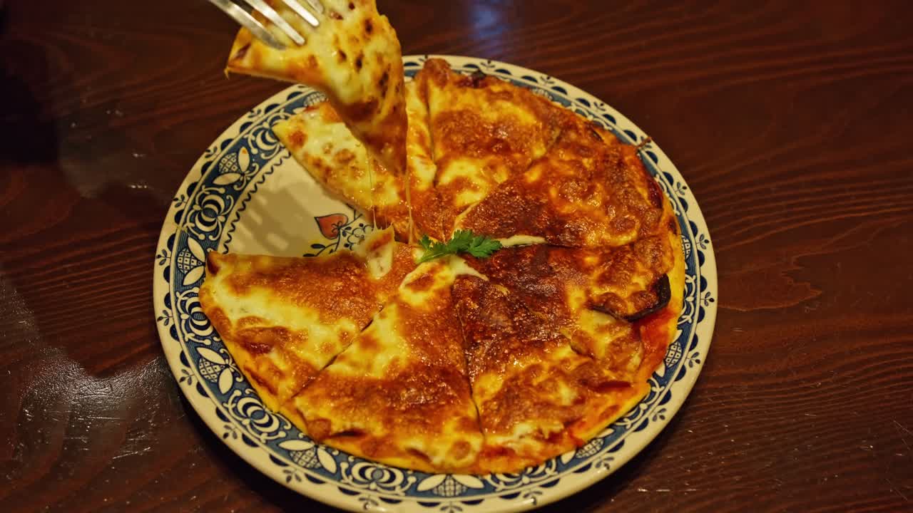 Cheese Pizza Slice Being Lifted in Warm Lit Italian Restaurant, Porcelain Plate on Wooden Table