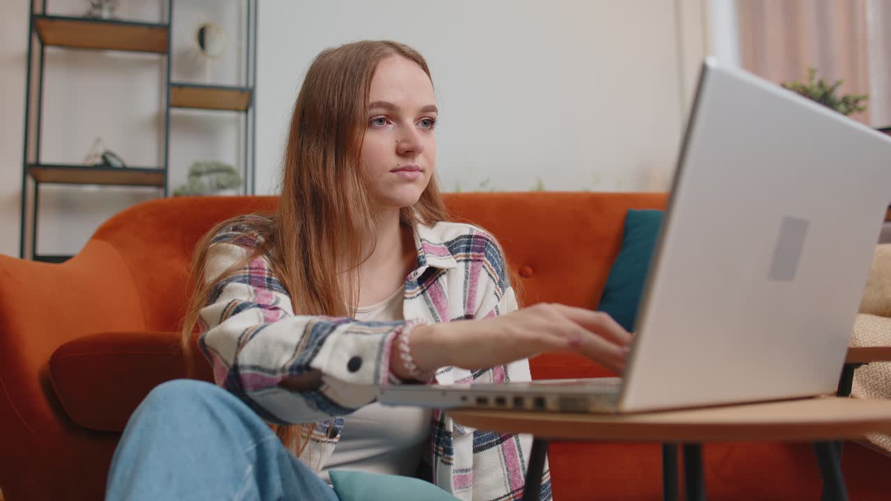 Young woman girl using laptop computer sitting on floor working online shopping from home office