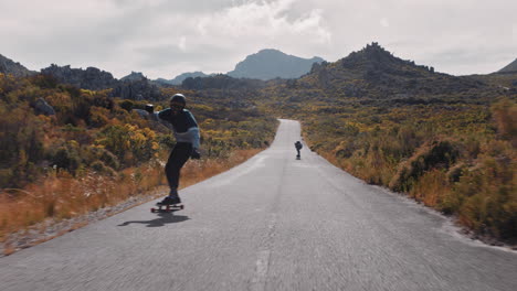 young man longboarding riding enjoying competitive race cruising on countryside road friends skating together using skateboard having fun