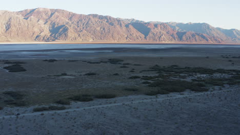 Drone-flying-low-over-rugged-and-harsh-terrain-valley-at-Death-Valley-National-Park,-California