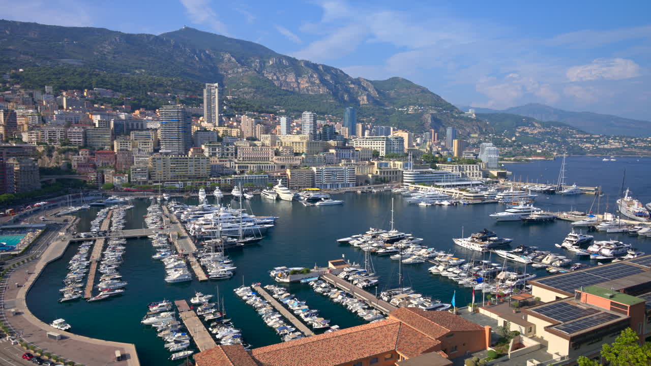 View of boats docked in the Monaco Marina with the skyline of the city on the background