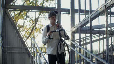 young man carrying a bicycle up stairs