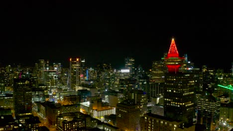 drone fly by on top of downtown vancouver canada during the night through vancouver lookout