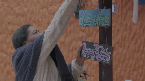 Slowmotion-shot-of-an-elderly-woman-making-sure-her-market-signs-are