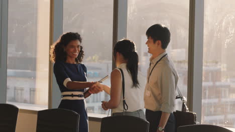 business people shaking hands consultant meeting international clients greeting with handshake planning partnership deal female executive working with shareholders in corporate office at sunset