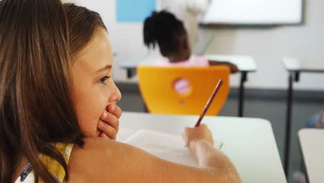 Schoolgirl-whispering-into-her-friends-ear-in-classroom