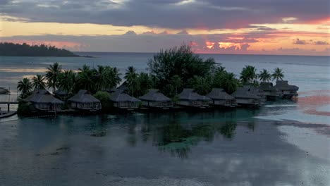 stunning vibrant pink orange sunset sun rays sofitel kia ora resort bungalow villas moorea island french polynesia aerial drone cooks opunohu bay lagoon coral reef pacific ocean circle right parallax