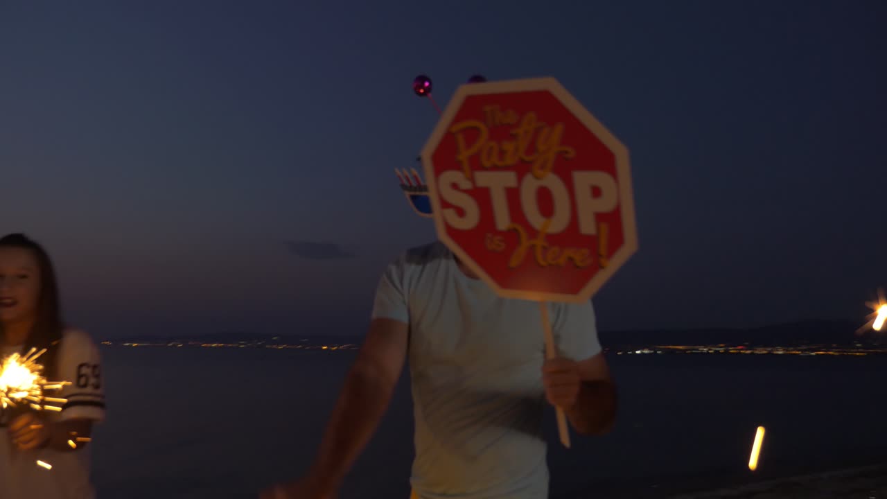 해변에서 반이는 불꽃으로 축하하는 친구들