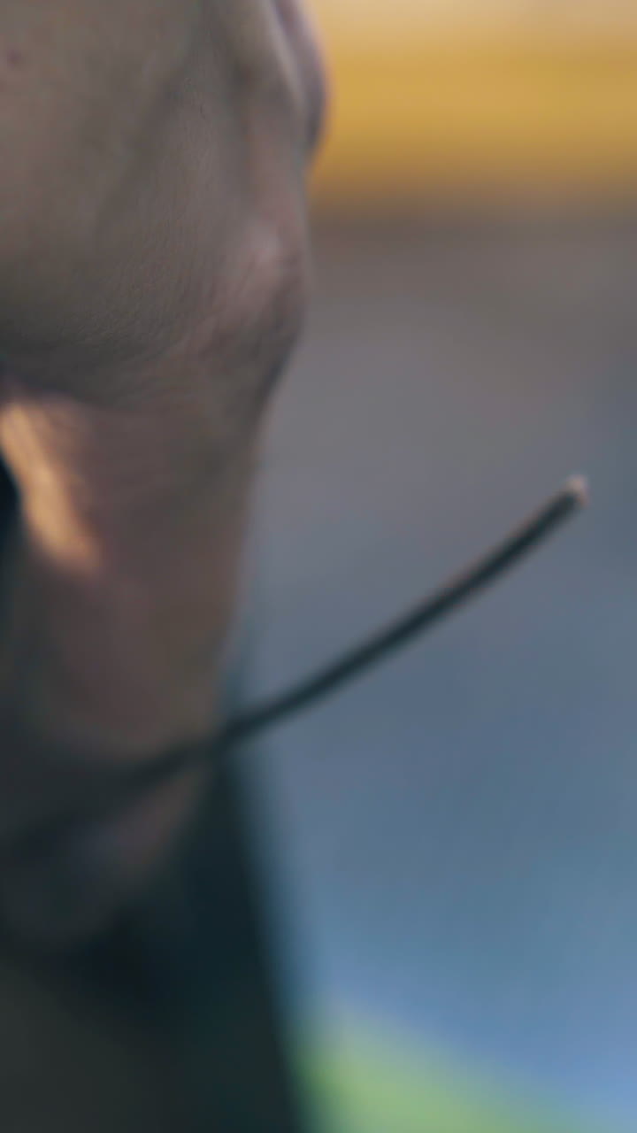 CU shot: young goldsmith forge-rolls white gold wire with machine tool at workplace in jewelry workshop close view
