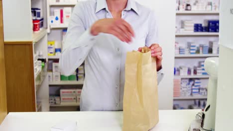 pharmacists packing medicine in paper bag