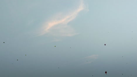 multiple colorful kites soaring in blue sky during makar sankranti festival. aerial view of traditional kite flying.