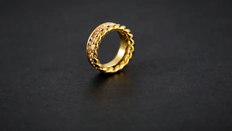 rotating golden knotted sparkly twin golden ring with zircons on black background. beautiful valentine's gift.