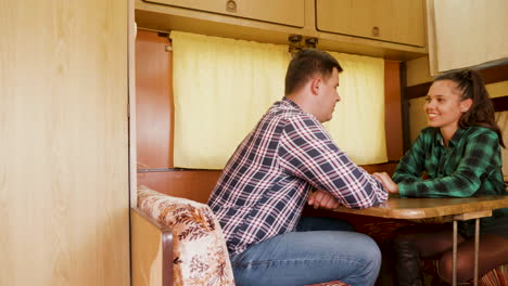 couple laughing together and holding hands inside of retro camper van