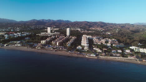 Aerial-moving-sideways-near-the-coastline-of-Cabopino,-Andalusia,-Spain