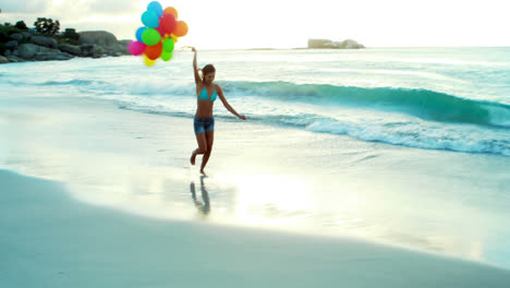 Mujer-Corriendo-En-La-Playa-Con-Globos