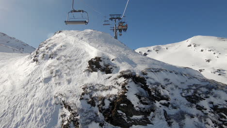 Skifahrer-Im-Skilift,-Die-An-Einem-Sonnigen-Tag-über-Einen-Schönen-Felsen-Fahren,-Weitschuss