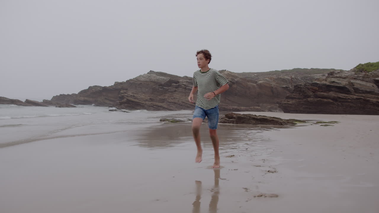 해변에서 실행하는 소년