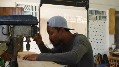 Surfboard-maker-using-drilled-machine-on-wooden-plank-4k