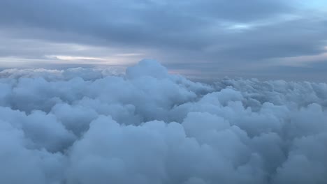 Pilot-POV-flying-over-some-stormy-clouds-with-a-pastel-color-sky-just-before-sunset