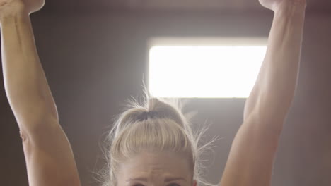 closeup on face of determined strong swedish woman doing weightlifting, fitness