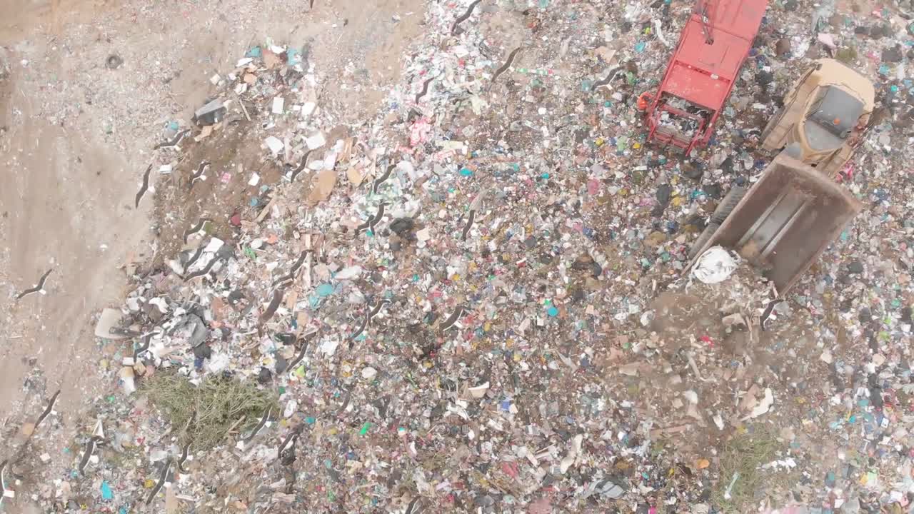 vehículos que limpian la basura apilada en un vertedero lleno de basura