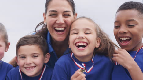 Niños-Con-Entrenadora-Mostrando-Las-Medallas-De-Los-Ganadores-En-El-Día-Del-Deporte.