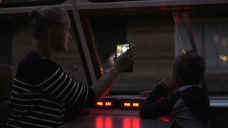 madre e hijo haciendo un viaje turístico por el agua por la noche en ámsterdam