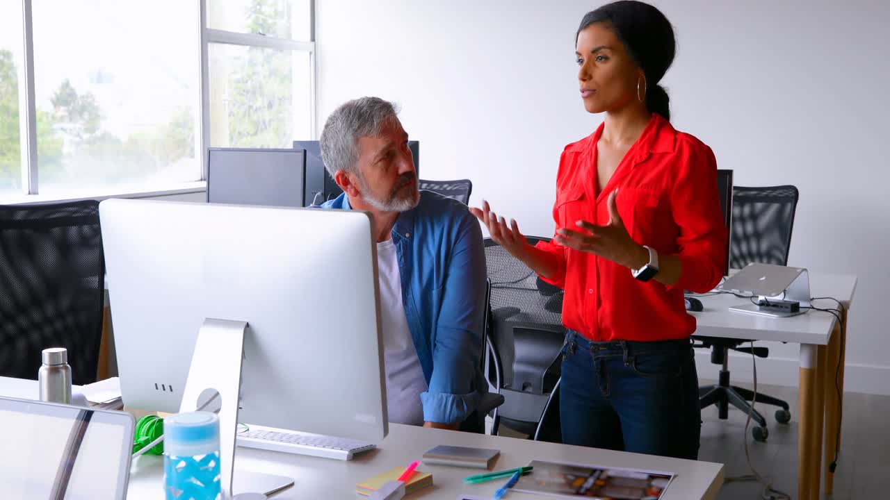 Executives discussing over desktop pc at desk 4k