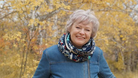 smiling senior woman in autumn park
