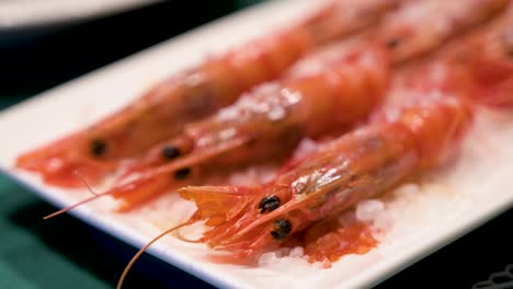 a narrow focus view of homemade oven-cooked red shrimps, adorned with sea salt, elegantly arranged on a clean white platter