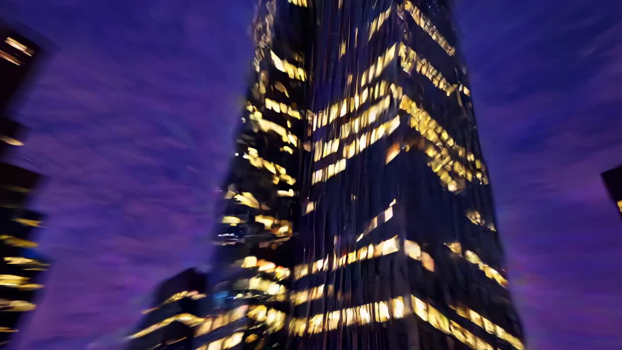 A dynamic video showcasing a skyscraper against a vibrant purple sky, with a blurred, energetic
