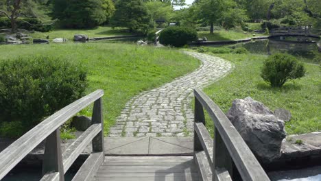 Pequeño-Puente-De-Madera-Sobre-El-Estanque-Con-Pavimentos-De-Piedra-En-El-Parque-Roger-Williams-En-Providence,-Rhode-Island,-Ee.uu.