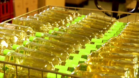 botellas de vino blanco con tapas verdes en una línea de embotellado