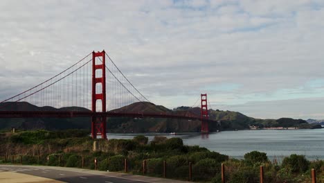 camera zooms toward golden gate bridge with soft light over bay and distant hills