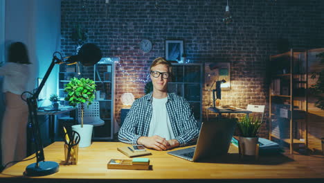 young man working late at night in home office