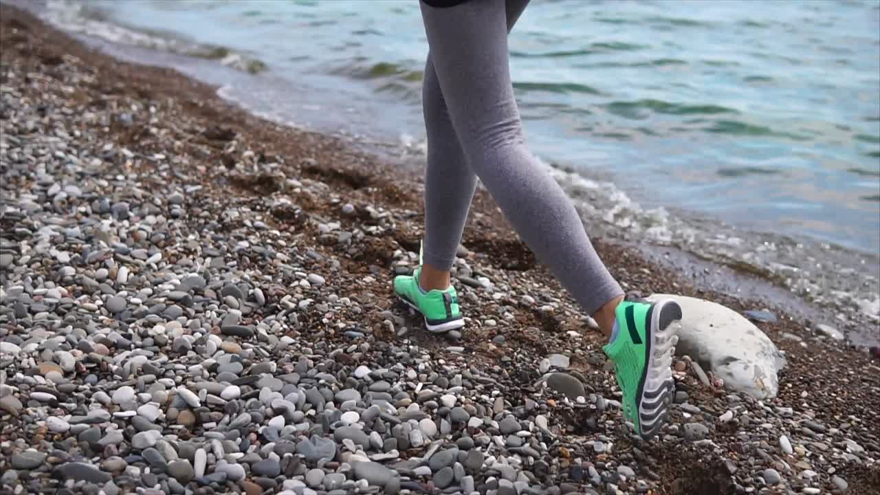 Woman walking on a pebble beach