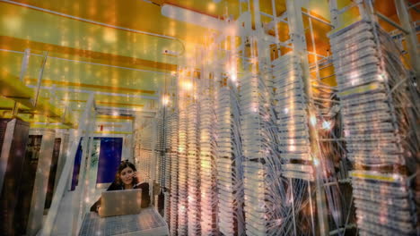 data processing over woman working on laptop in server room