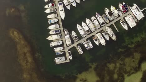 toma aérea de drones, mirando directamente hacia abajo en un yate en un pequeño puerto deportivo en el lago macquarie, australia