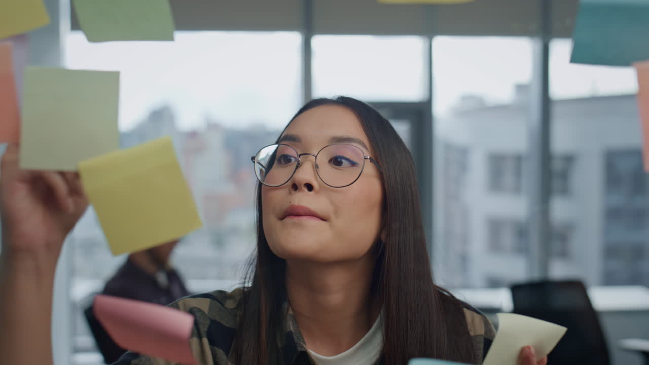 mujer seria observando tablero de vidrio en el retrato de la oficina. tareas de escritura especializada