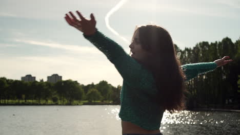 gorgeous italian woman with arms raised looking at sunset view over the lake