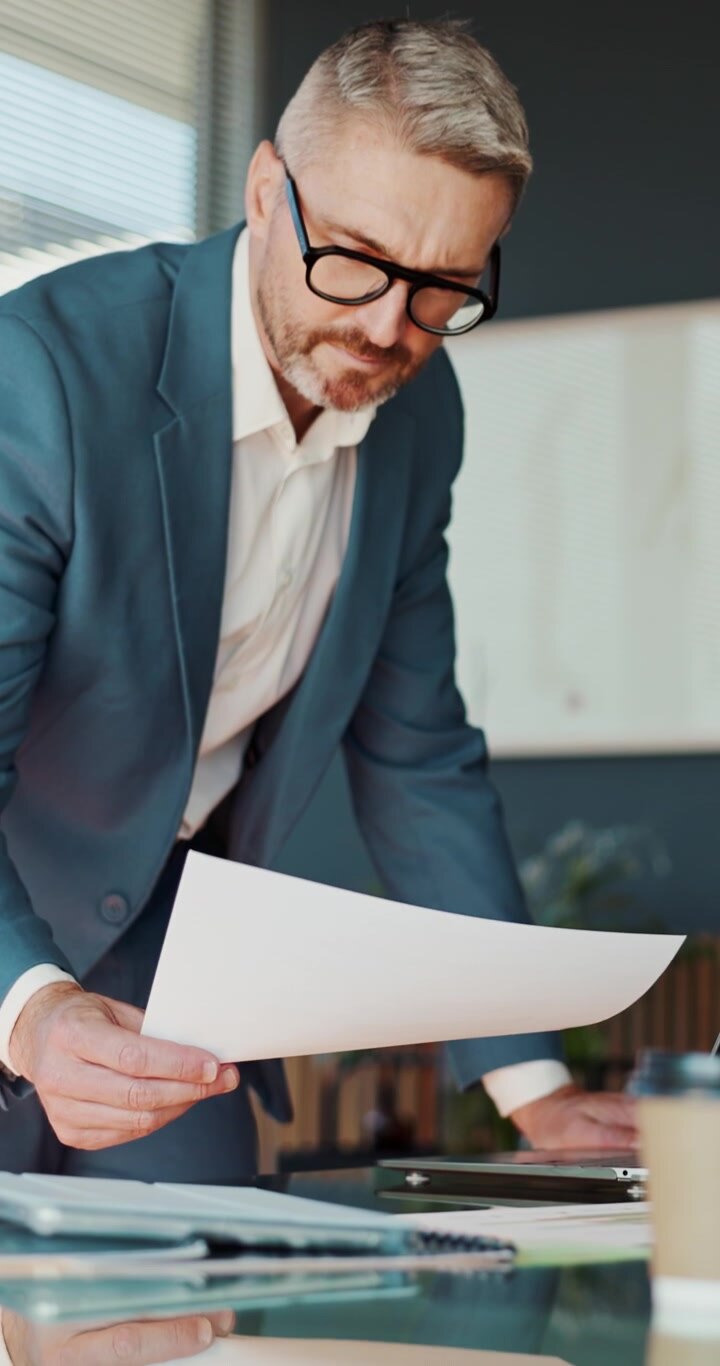 Professional Businessman Reviewing Documents in Modern Office