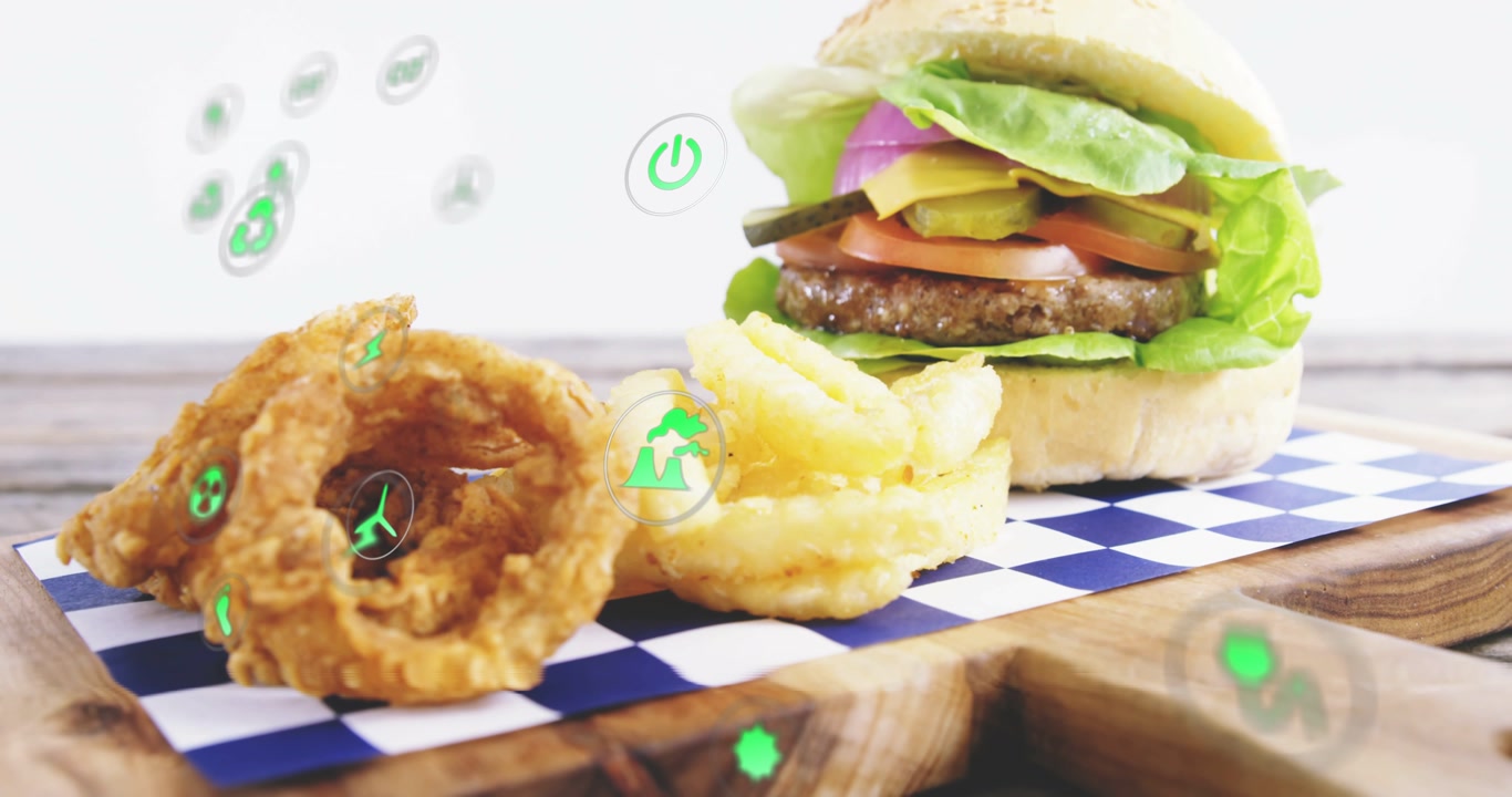Green eco icons drifting left camera sliding right tool placing chili atop bun creating eco overlay