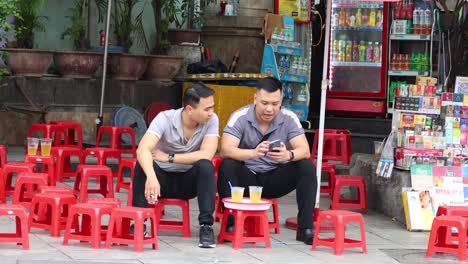 two friends talking and using smartphones outside.