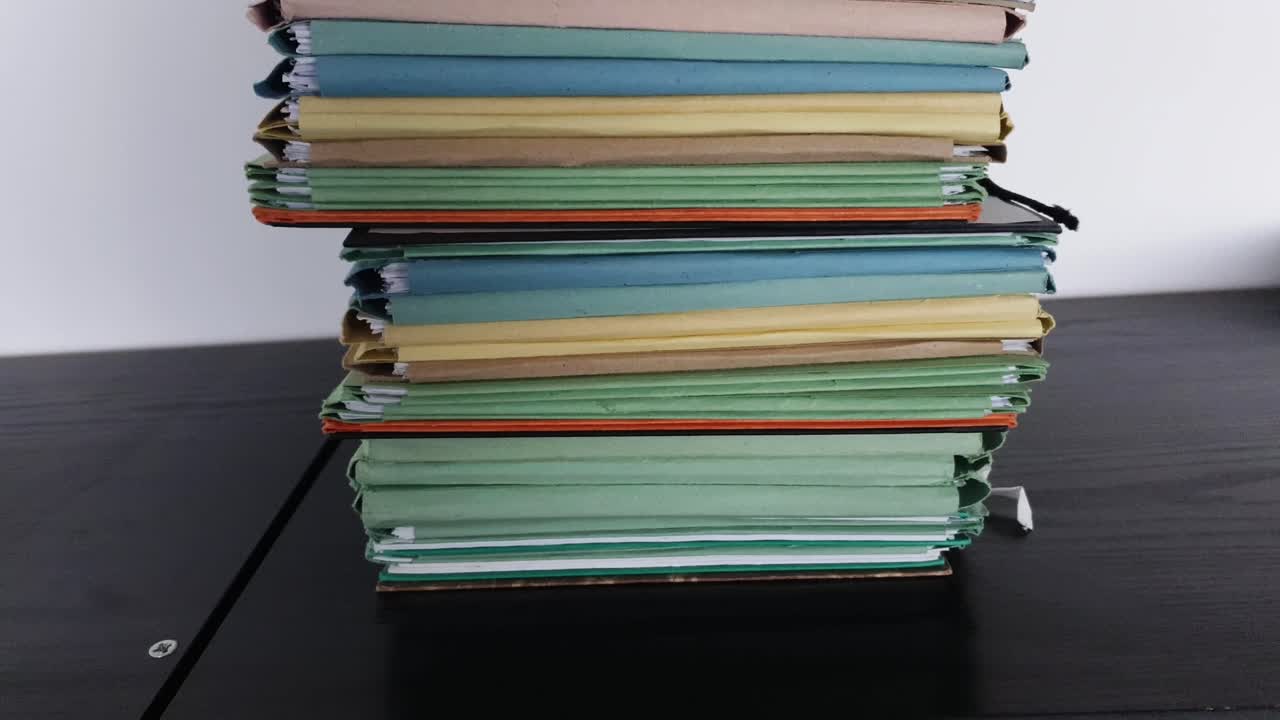 Camera movement along a file shelf. The files are old, the paper is yellowed.