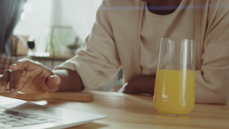 Mujer-Afroamericana-Usando-Laptop-Durante-El-Desayuno-En-Casa