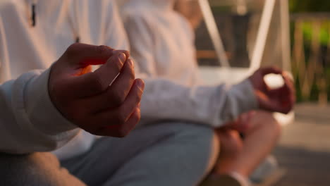 man meditates in lotus pose outdoors closeup. yoga practitioner uses murdas for concentration at spiritual retreat. harmony and relaxation techniques