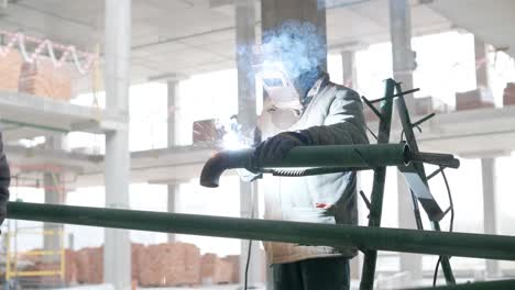 professional welders are working in the factory wearing safety equipment. metalwork manufacturing, industrial process.