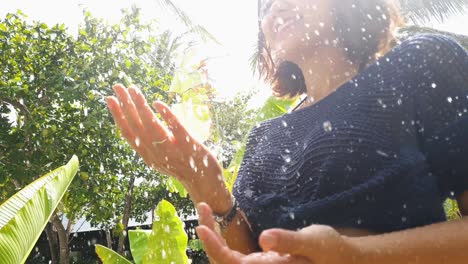 mujer joven con lente arco iris, primer plano de la cintura, juega en la ducha de sol.