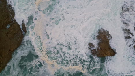 drone ocean waves hitting wild volcanic shore. aerial view scenic coastline