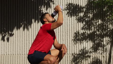 Mexican-sports-man-rehydrating-while-training-outdoors-on-sunny-day